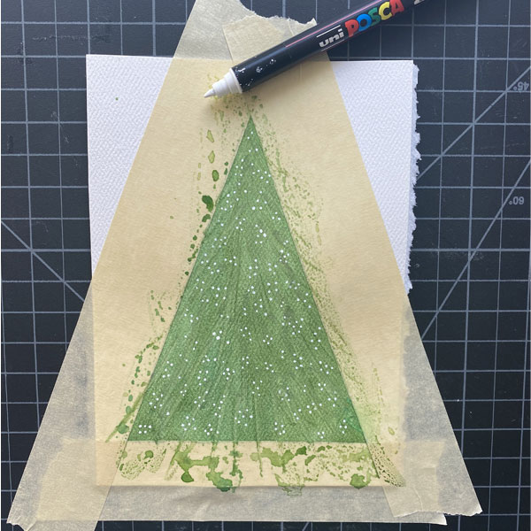 Small white dots over textured green watercolor wash within masking taped triangle on small watercolor sheet. White paint marker off to side.